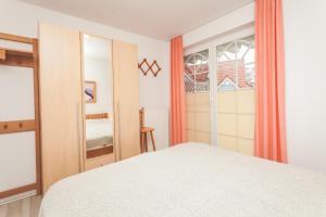 a bedroom with a white bed and a window at Fritz-Reuter-Straße 2 Whg 2 in Zingst