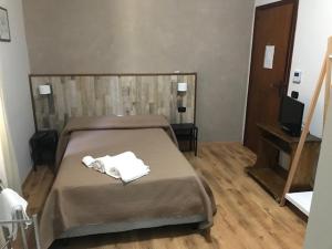 ein Schlafzimmer mit einem Bett mit zwei Handtüchern darauf in der Unterkunft IL TUCANO in Pergusa