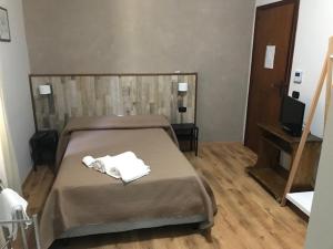 a bedroom with a bed with two towels on it at IL TUCANO in Pergusa