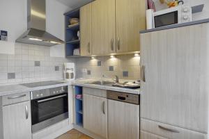a small kitchen with a sink and a refrigerator at Villa "Meereslust" , Whg 1 in Zingst