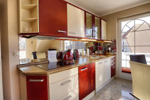 a kitchen with white cabinets and red appliances at Villa Sonnenuhr, FW 8 in Zingst