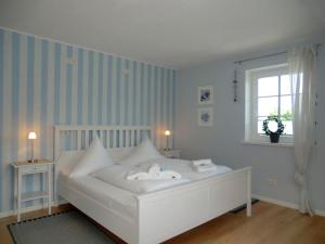 a white bed in a room with a window at Nordwind in Oevenum