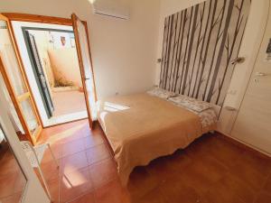 ein kleines Zimmer mit einem Bett und einem Spiegel in der Unterkunft Aba Maya Alghero in Alghero