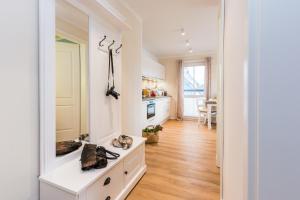 a kitchen with white cabinets and a hardwood floor at Whg 13 - De Fischer un sin Fru in Zingst
