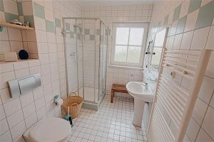ein Bad mit einer Dusche, einem WC und einem Waschbecken in der Unterkunft Am Deich 09 in Zingst