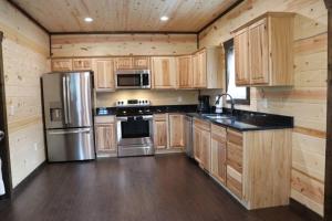 a kitchen with wooden cabinets and a stainless steel refrigerator at Chalet Village- Amazing Mountain Views - Piney Butt Place in Gatlinburg