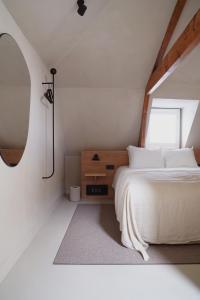 a bedroom with a white bed and a window at Hotel âme in Rotterdam
