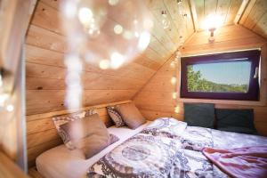 a bedroom in a log cabin with a bed and a window at Szalejówka Domki in Kłodzko