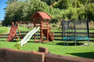 a playground with two slides and a swing set at Szalejówka Domki in Kłodzko