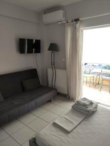 a living room with a couch and a large window at Ostria in Preveza