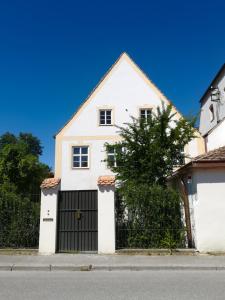 een wit huis met een zwarte garage bij Ferienwohnung Hofmarkrichterhaus in Polling