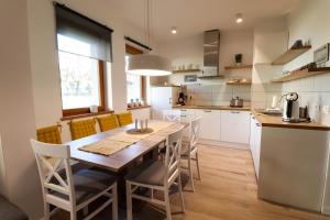 uma cozinha e sala de jantar com uma mesa de madeira e cadeiras em Bohinj - Old Village House em Bohinj