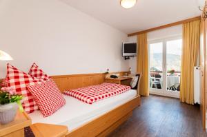 a bedroom with a bed with red and white pillows at Baumgartenschneid in Bad Wiessee