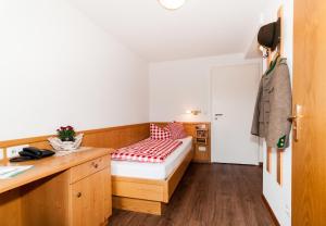 een kleine slaapkamer met een bed en een bureau bij Baumgartenschneid in Bad Wiessee