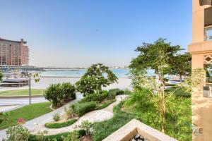 Lively 1 BR at Al Nabat Shoreline 8 Palm Jumeirah by Deluxe Holiday Homes في دبي: اطلالة على المياه من المبنى