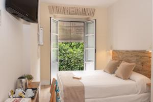 sypialnia z łóżkiem i dużym oknem w obiekcie Hotel Boutique Elvira Plaza w Sewilli +37 zdjęć