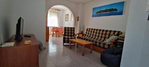 een woonkamer met een bank en een tafel bij La Casa de Gonzalo in Gran Alacant