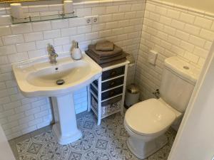 a white bathroom with a sink and a toilet at Zum alten Müller-Jäger in Lübbenau