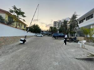 um parque de estacionamento com uma rua com cadeiras brancas em Paradise Resort Apartments em Nyali