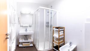 bagno bianco con doccia e lavandino di Bella Mura Blue Apartment a Moravske Toplice