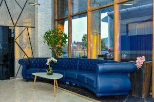 a blue couch in a room with a table at Hotel Story in Skopje