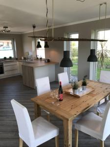 a kitchen and dining room with a wooden table and white chairs at Ferienhaus Mau in Meeschendorf