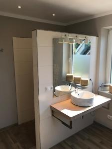 a bathroom with two sinks and a large mirror at Ferienhaus Mau in Meeschendorf