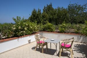 a table and two chairs on a patio with trees at Hotel Bellavista in Anacapri