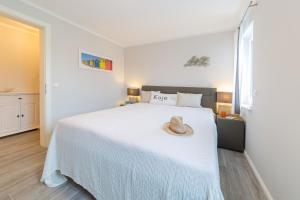 a bedroom with a white bed with a hat on it at Whg 01 - Koje M in Zingst