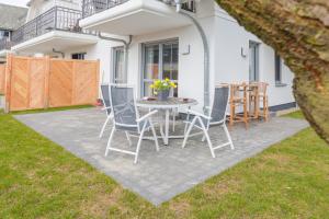 a patio with a table and chairs in a yard at Whg 01 - Koje M in Zingst