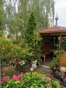 einen Garten mit einem Holzpavillon und Blumen in der Unterkunft Gästezimmer- und Ferienzimmer Am Gewölbekeller Meißen in Meißen