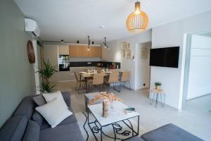 a living room with a couch and a dining room at Rez de villa de charme-piscine-3 chambres 6 pers in Saint-Raphaël