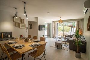 a dining room and living room with a table and chairs at Rez de villa de charme-piscine-3 chambres 6 pers in Saint-Raphaël