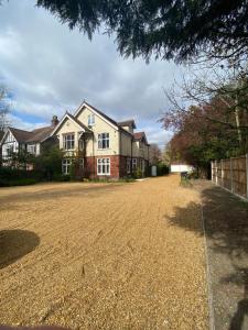 a house with a gravel driveway in front of it at Pristine 2 bedroom apartment with off street parking in Norwich