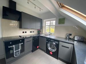 a kitchen with a washer and a washing machine at Pristine 2 bedroom apartment with off street parking in Norwich