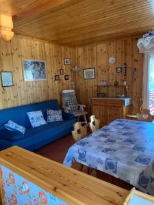 a living room with a blue couch and a bed at Casa Lulu' in Predazzo