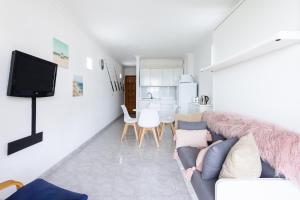 a living room with a couch and a kitchen at Home2Book Sea Front Vista Marina, Los Cristianos in Arona