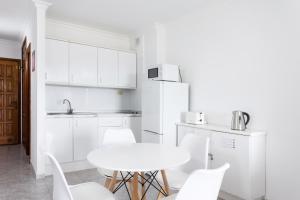 biała kuchnia ze stołem i białymi krzesłami w obiekcie Home2Book Sea Front Vista Marina, Los Cristianos w Aronie +16 zdjęć