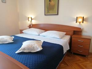 1 dormitorio con 1 cama con 2 almohadas en Apartments Melinda, en Baška Voda