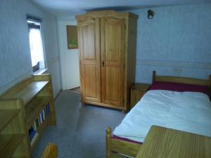 1 dormitorio con 1 cama y armario de madera en Haus Saskia, en Wutha-Farnroda