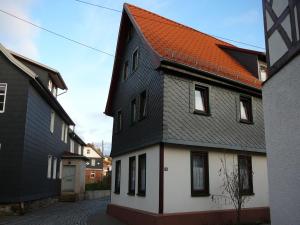 czarno-biały dom z pomarańczowym dachem w obiekcie Haus Saskia w mieście Wutha