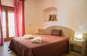 1 dormitorio con 1 cama con toallas en Camere al Santuario-Gli Arcangeli, en Monte SantʼAngelo