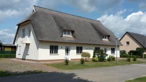 a white house with a thatched roof at Häuschen "Tante Waltraut" in Garz-Usedom