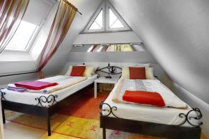 two beds in a attic room with two windows at Catherin in Zingst