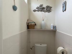 baño con aseo y jarrón en un estante en Me Oissie, en Egmond aan Zee 17 fotos más