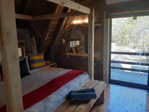 - une chambre avec un lit dans une maison en bois dans l'établissement African Bush Escape, à Marloth Park