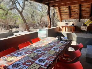 une table avec des chaises rouges et une nappe sur une table dans l'établissement African Bush Escape, à Marloth Park