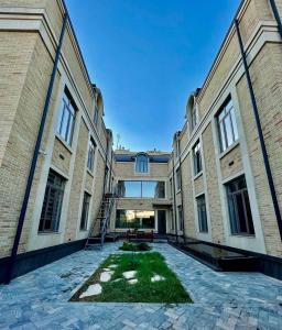 an exterior view of a building with a courtyard at Alpha Plaza Hotel & SPA in Tashkent