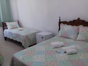 a bedroom with two beds and two pillows on it at Quartos Praia do Foguete Cabo Frio in Cabo Frio