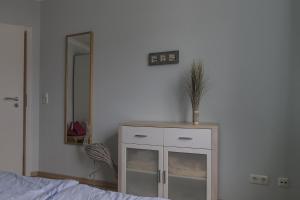 a bedroom with a white cabinet and a mirror at An der Alten Rotbuche, Whg 3 in Zingst